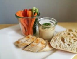 Gegrilltes Fleisch mit Hummus, Fladenbrot und Gemüsesticks